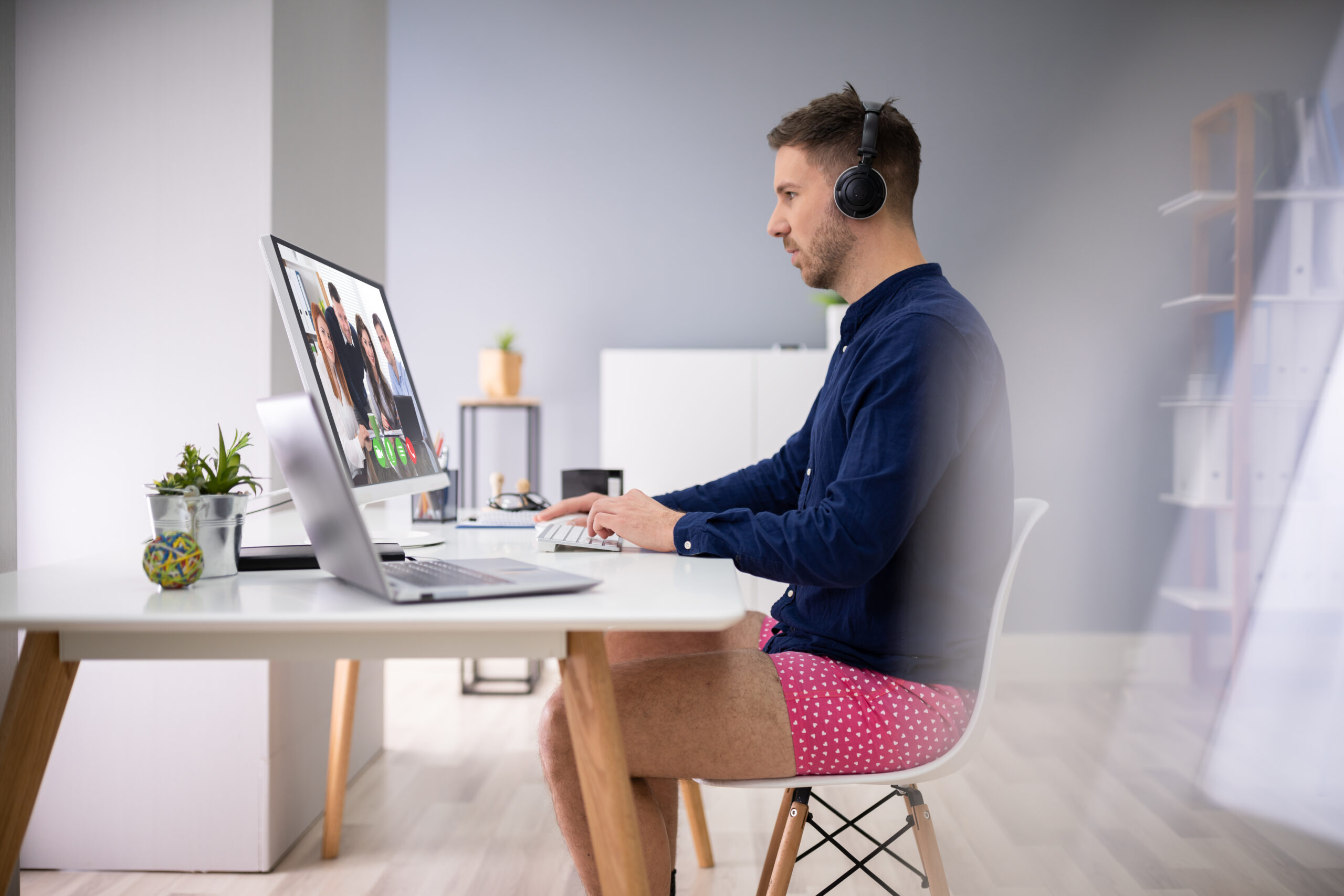 Mann sitzt am Computer mit kurzer Hose Mann sitzt am Computer mit kurzer Hose